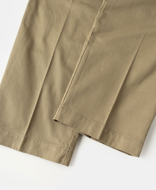 Khaki trouser hem with cuffed edge and side seam stitching.