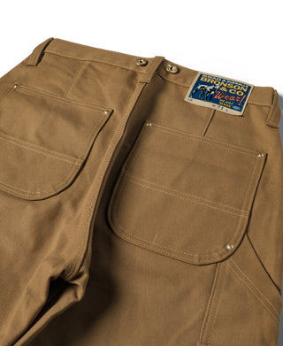 Brown canvas double knee pants with front pockets and metal buttons