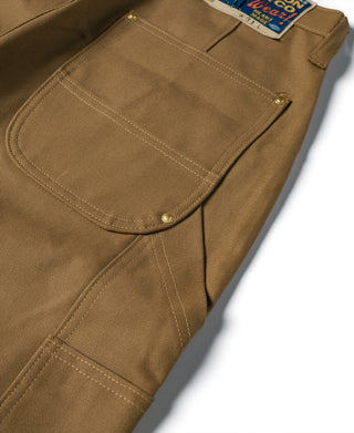 Brown canvas pants leg with rounded front pocket and visible stitching