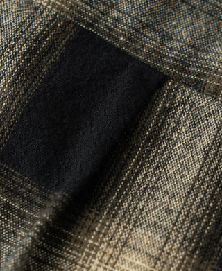 Brushed cotton ombre plaid fabric detail with dark patch and textured weave