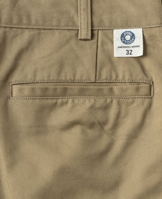 Khaki cotton twill trousers close-up with size label and stitched waistband pocket