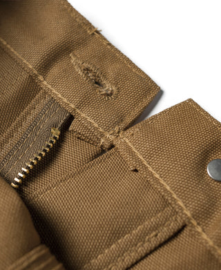 Brown canvas waistband with belt loop, fly stitching, and zipper fly edge