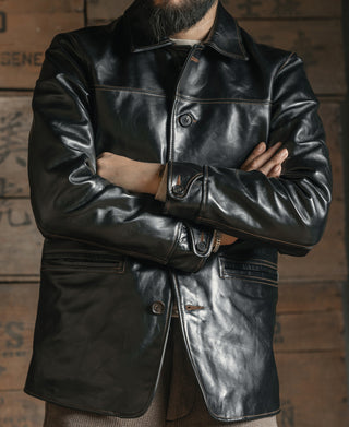 Black leather coat front with buttons, pointed collar, and welt pockets