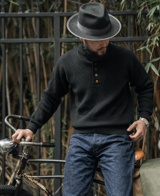 Black wool high-neck sweater on model, front button placket and ribbed hem