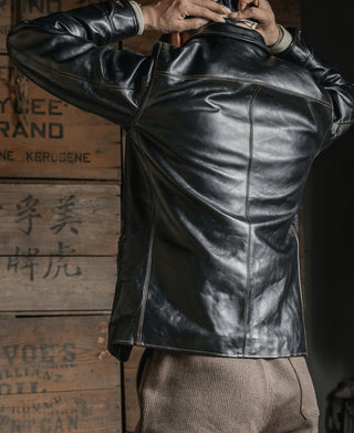Back of the black leather coat showing its panel seams and collar