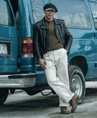 Olive wool high-neck sweater with five-button placket, worn with light trousers
