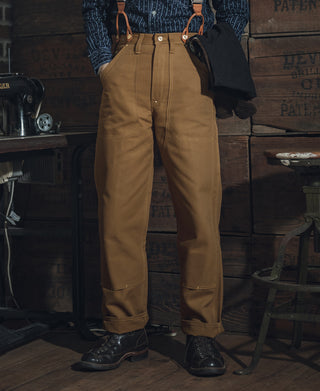 Brown canvas double-knee work pants with leg seams and reinforced knee panels.