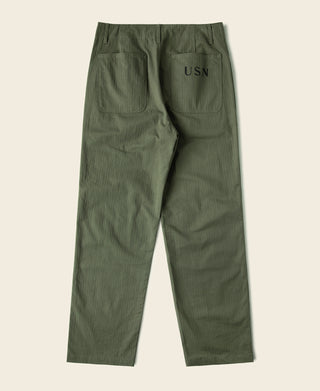 Olive cargo pants with back pockets and stitched “USN” graphic on right leg.