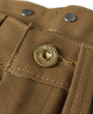 Brown canvas pants close-up of metal snap button at waistband