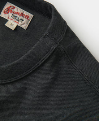 Dark crew-neck athletic T-shirt with reinforced shoulder seam and ribbed collar.