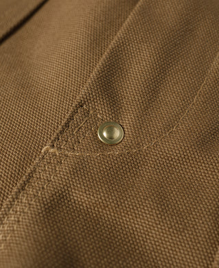 Brown canvas work pants close-up of stitched pocket corner and metal button