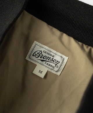Genuine Bronsom Fabric label on tan lining inside black bomber jacket, size M
