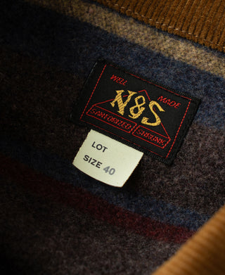 Denim jacket size label area with brand tag and markings on dark indigo fabric