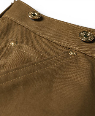 Brown canvas pants close-up of waistband with metal buttons and inner seam