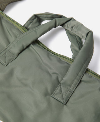 Olive nylon helmet bag with handles and green zipper, quilted seams