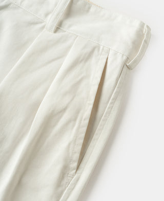 White trouser leg with pressed pleats and straight cuffed hem.