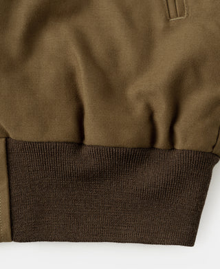 Brown bomber jacket ribbed hem band with textured knit and seam lines.