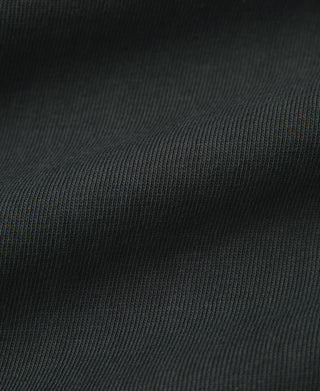 Dark tubular knit fabric texture on athletic T-shirt with fine ribbed weave.