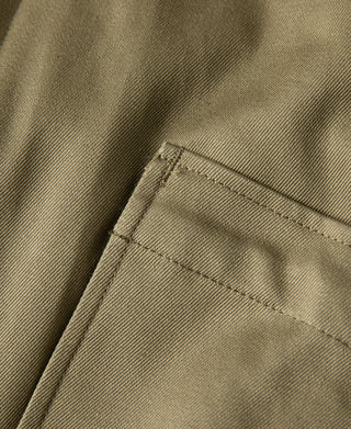 Yellow-green jacket side pocket with stitched flap and fabric lining.