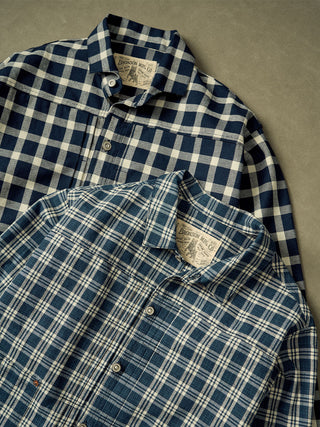 The top jacket is blue and white, while the bottom jacket is a darker blue and white plaid.