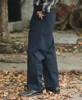 Navy cotton twill trousers, angled side view showing relaxed fit and front pocket.