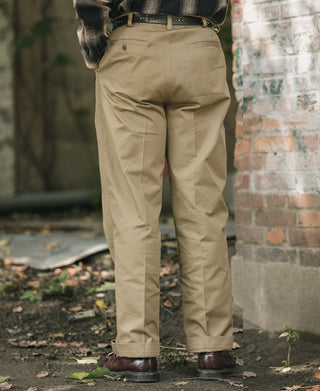 Khaki double-pleat cotton twill trousers on model with cuffed leg openings