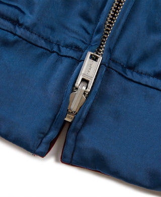 Blue reversible jacket bottom hem close-up with metal zipper and stitched seam